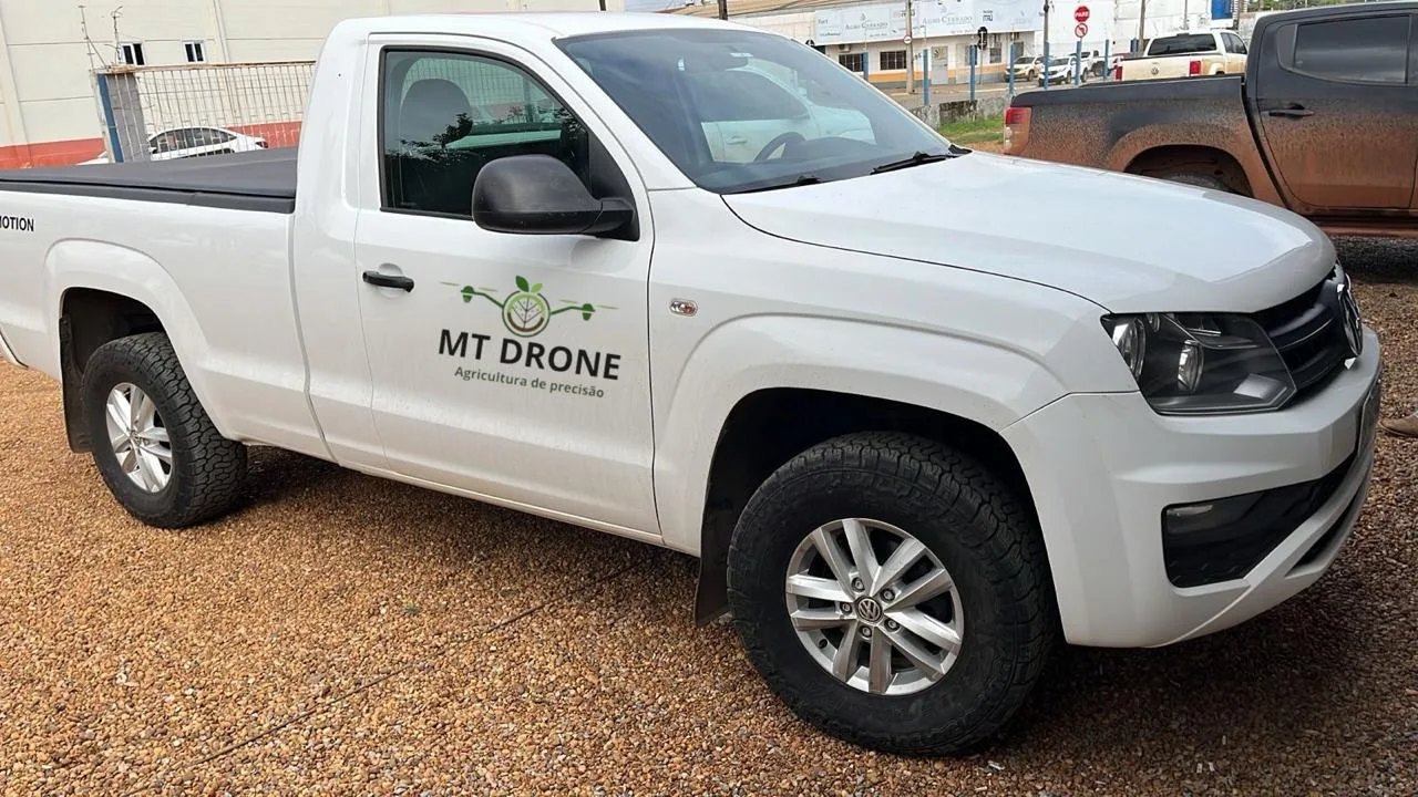 Camionete branca com adesivo MT Drone — equipamento próprio chega até a fazenda